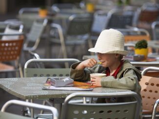 Een jonge jongen geniet zichtbaar van zijn ijsje in de buitenlucht