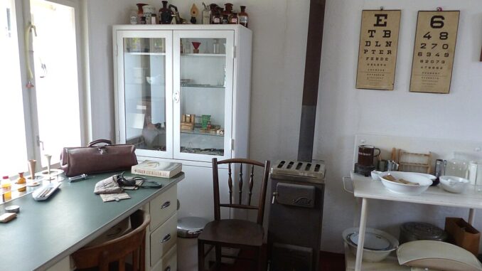 Interieur van een huisartsenpraktijk met behandelkamer, symbool voor de drukte in Berlijnse praktijken tijdens het corona- en griepseizoen