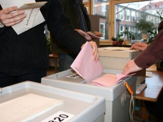 Mensen stemmen in een Duits stembureau