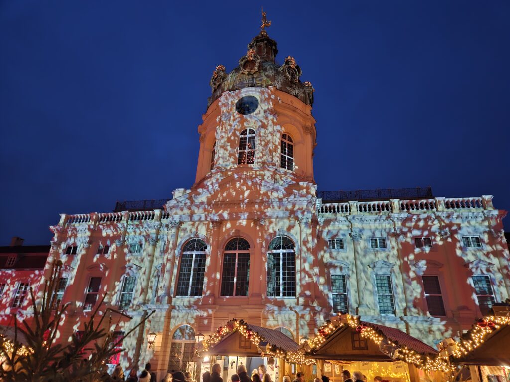 Kerstmarkt bij Schloss Charlottenburg in Berlijn met feestelijke verlichting op de gevel