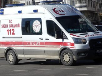 Turkse ambulance met rood-witte 112-markering rijdend door een stad in Turkije.