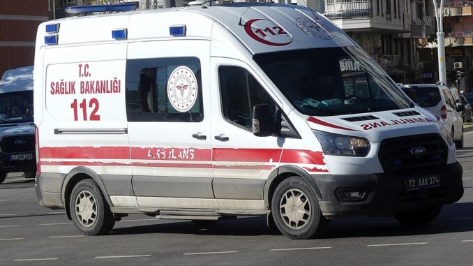 Turkse ambulance met rood-witte 112-markering rijdend door een stad in Turkije.