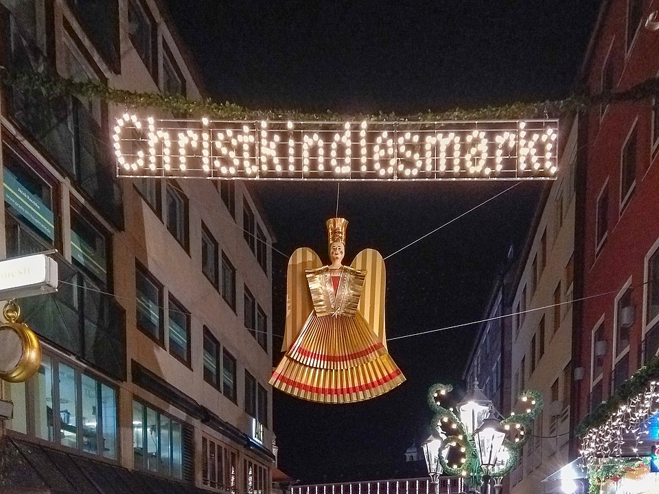 Verlichte ingang van de Christkindlesmarkt in Neurenberg met gouden engelfiguur