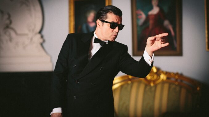 Zanger in smoking tijdens scène uit de musical Falco meets Amadeus.