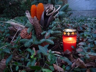 Graflicht en grafstuk op Duitse begraafplaats tijdens Totensonntag