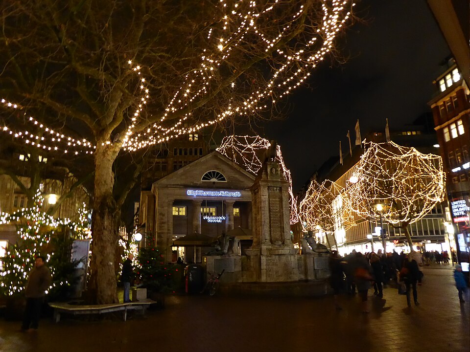 Verlichte kerstmarkt op de Rathausmarkt in Hamburg met historische gevels en kerstverlichting.