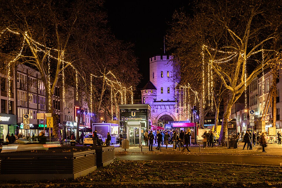 Verlichte bomen en kraampjes op de kerstmarkt aan de Chlodwigplatz in Keulen.