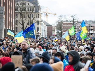 Grote menigte tijdens een solidariteitsdemonstratie voor Oekraïne op de Roncalliplatz in Keulen, met Oekraïense en EU-vlaggen.