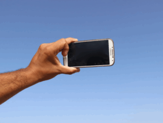 Hand houdt een smartphone omhoog, symbool voor stiekeme opnamen in de openbare ruimte