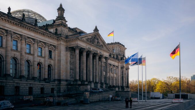 Reichstagsgebouw in Berlijn met Duitse en NAVO-vlaggen bij het westportaal
