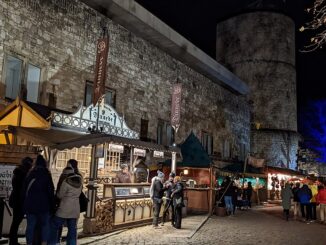 Kerstmarkt aan het Hohen Ufer in Hannover met verlichte kraampjes en de Beginenturm op de achtergrond.