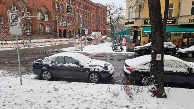 Sneeuw op straat en geparkeerde auto’s op oudejaarsdag in Berlijn