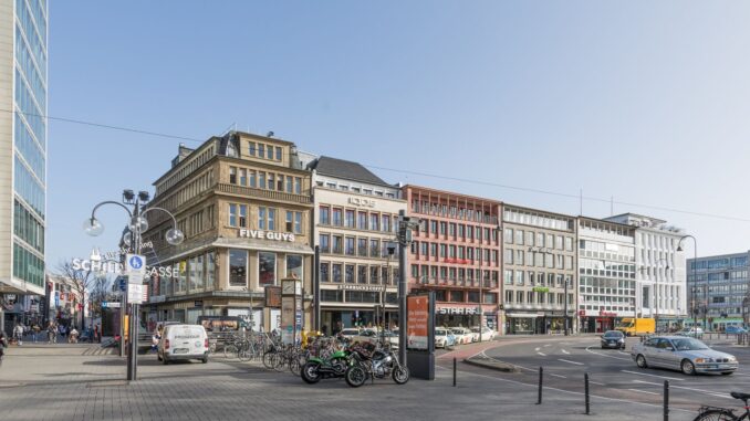 Neumarkt in Keulen met gebouwen aan de Schildgasse en verkeer op het plein