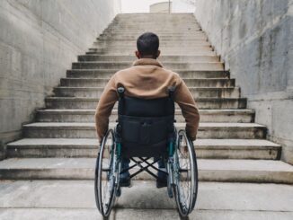 Man in rolstoel kijkt naar een trap zonder lift als symbool voor gebrekkige toegankelijkheid in Duitsland