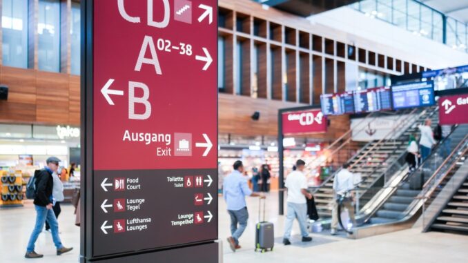 Terminalhal van luchthaven BER in Berlijn met bewegwijzering naar gates en uitgang