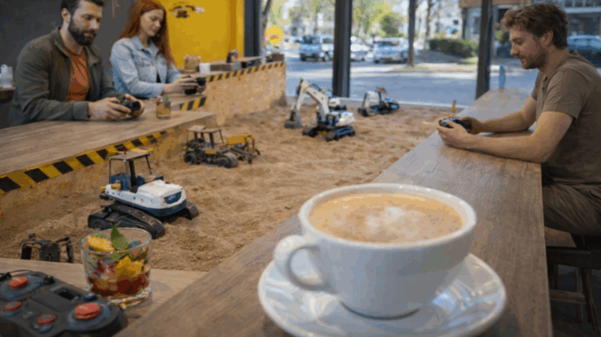 Bezoekers besturen mini-graafmachines in een zandbak terwijl ze koffie drinken in een bijzonder café in Hannover