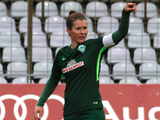 Marie-Louise Eta langs de zijlijn tijdens een voetbalwedstrijd