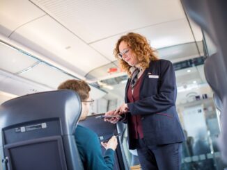 Conductrice controleert tickets van reizigers in een ICE-trein van Deutsche Bahn.