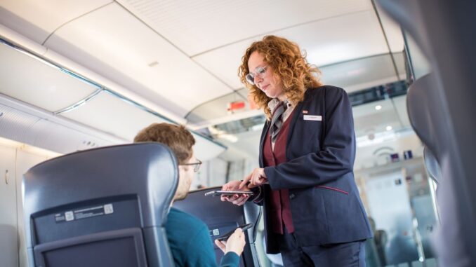 Conductrice controleert tickets van reizigers in een ICE-trein van Deutsche Bahn.