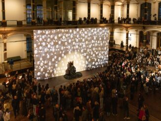 Grote installatie met projectie en publiek in de Gropius Bau in Berlijn tijdens de tentoonstelling Balkan Erotic Epic