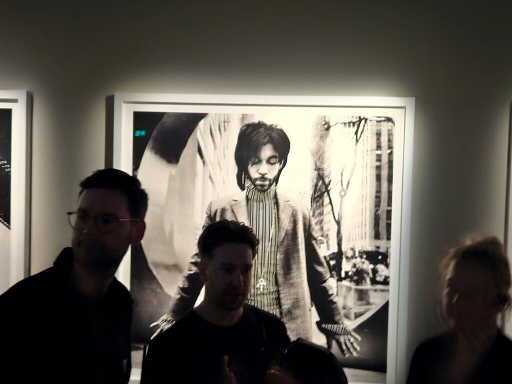 Bezoekers bekijken een iconisch zwart-witportret van Prince tijdens de Anton Corbijn-tentoonstelling in Fotografiska Berlin