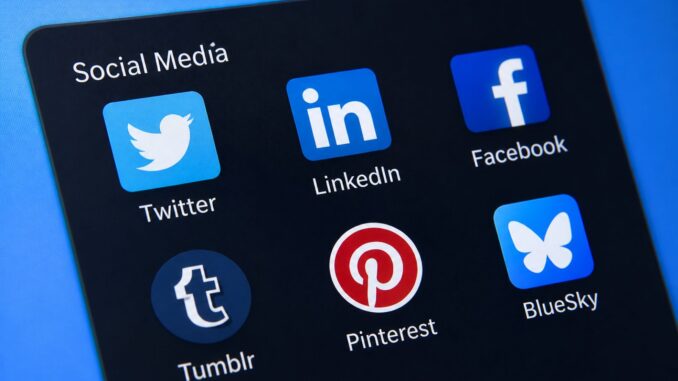 Smartphonescherm met social media apps zoals X (Twitter), LinkedIn, Facebook en Bluesky