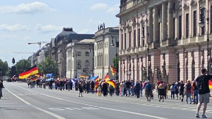 Demonstranten met Duitse vlaggen trekken over Unter den Linden richting de Brandenburger Tor in Berlijn.