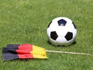 Duitse vlag naast een voetbal op een grasveld