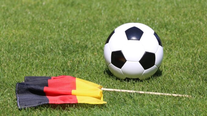 Duitse vlag naast een voetbal op een grasveld