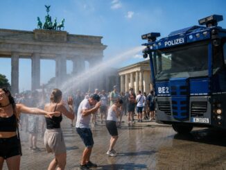 Berlijnse politie zorgt met een waterkanon voor verkoeling van bezoekers bij de Brandenburger Tor tijdens de extreme hitte.