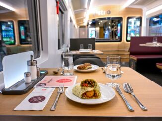 Interieur van een restauratierijtuig in een ICE-trein van Deutsche Bahn met een maaltijd op tafel.