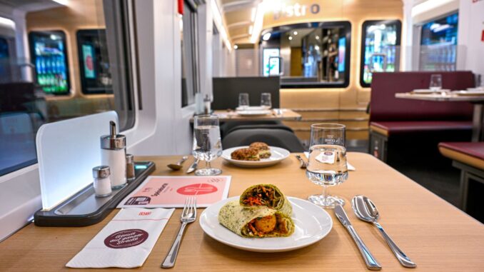 Interieur van een restauratierijtuig in een ICE-trein van Deutsche Bahn met een maaltijd op tafel.
