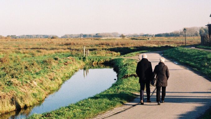 Ouder echtpaar wandelt over een landelijk pad. Regelmatige beweging kan bijdragen aan een sterker immuunsysteem op latere leeftijd.