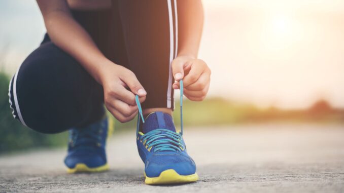 Hardloopster strikt haar veters voor een lange looptraining. Illustratie bij het wereldrecord van Joyce Hübner met 367 marathons in 367 dagen.