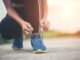 Hardloopster strikt haar veters voor een lange looptraining. Illustratie bij het wereldrecord van Joyce Hübner met 367 marathons in 367 dagen.