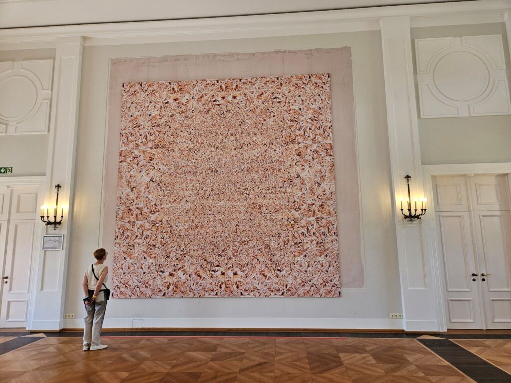 Bezoeker bekijkt het monumentale kunstwerk Hard String van Monica Bonvicini tijdens de tentoonstelling Freiraum Kunst in Schloss Bellevue.