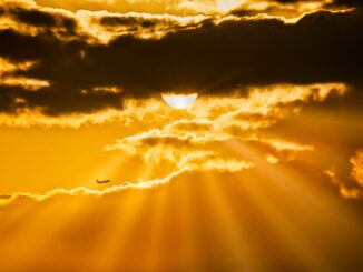 Zonlicht breekt door donkere wolken tijdens warm weer.