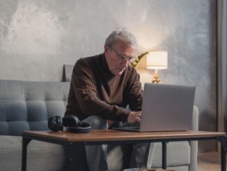 Oudere werknemer werkt op een laptop vanuit huis terwijl Duitsland zich voorbereidt op de pensionering van miljoenen babyboomers.