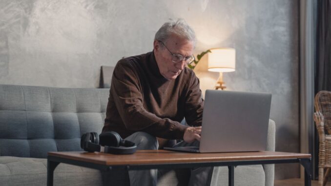 Oudere werknemer werkt op een laptop vanuit huis terwijl Duitsland zich voorbereidt op de pensionering van miljoenen babyboomers.
