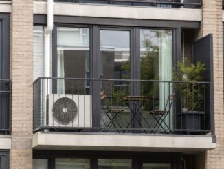 Buitenunit van een split-airco op het balkon van een appartement.