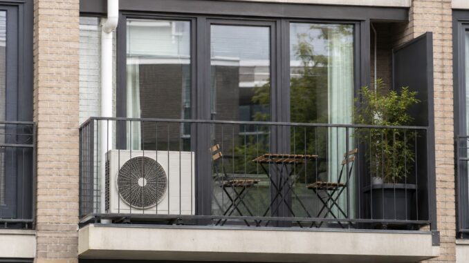 Buitenunit van een split-airco op het balkon van een appartement.