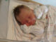 Pasgeboren baby in een ziekenhuisbed als illustratie van het dalende geboortecijfer in Duitsland.