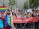 Deelnemers aan ColognePride met een spandoek van Queere Jugend NRW